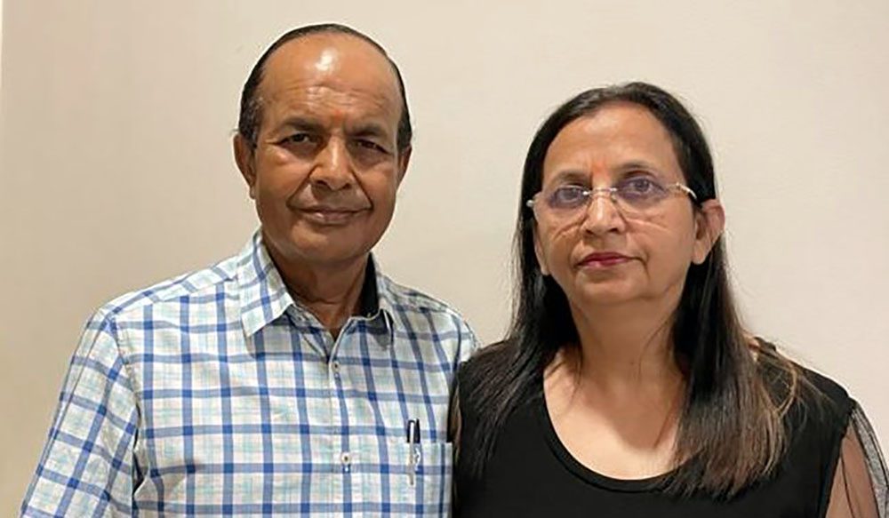 Naresh Aggarwal，医学博士，站在他的妻子Usha旁边的白色墙前