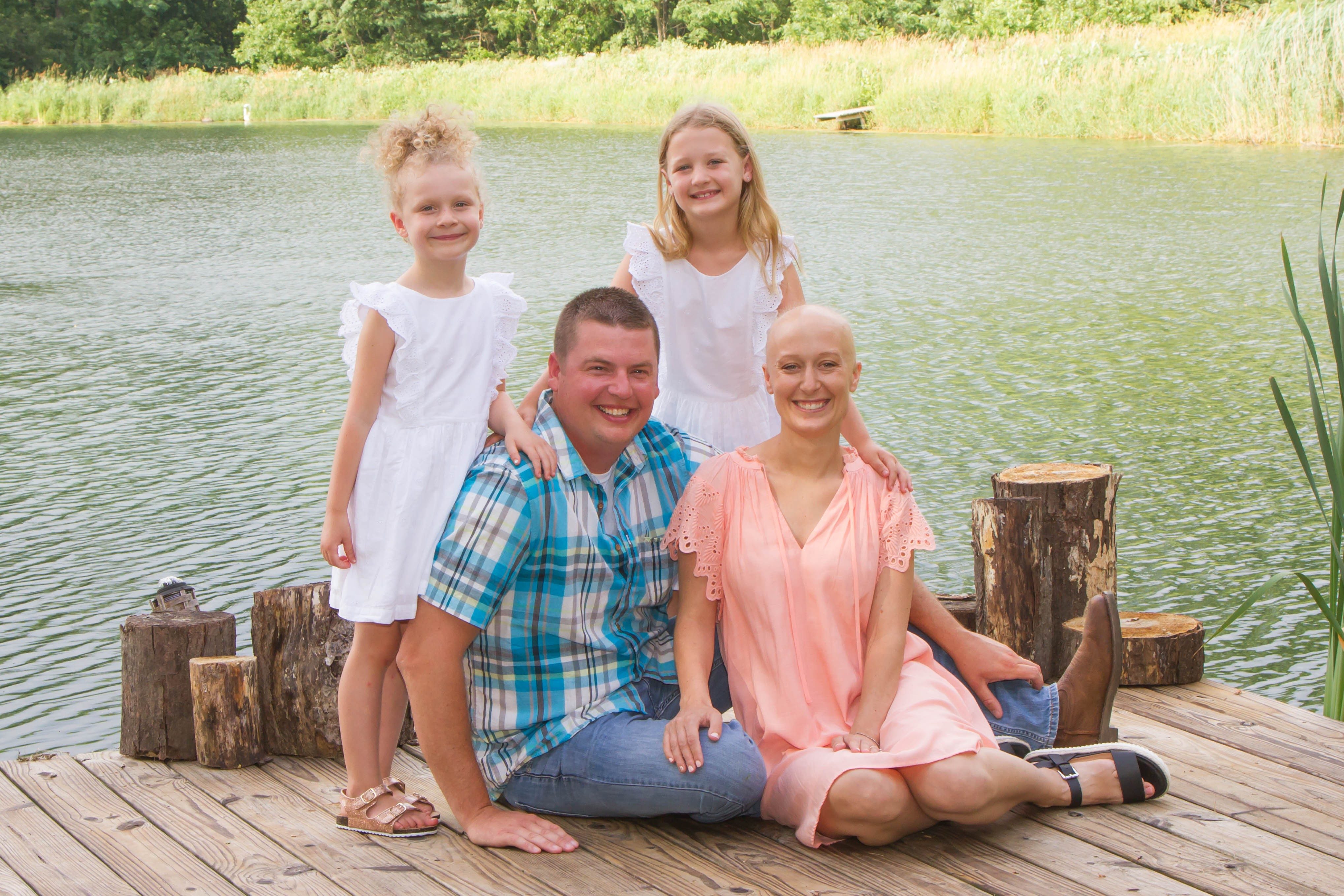 胸腺瘤幸存者Kirsti Hoopingarner坐落在前湖旁边的她的丈夫和两个女儿。