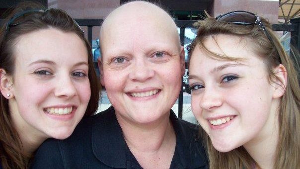 卵巢癌幸存者帕姆Scarpino姿势与她的两个女儿。