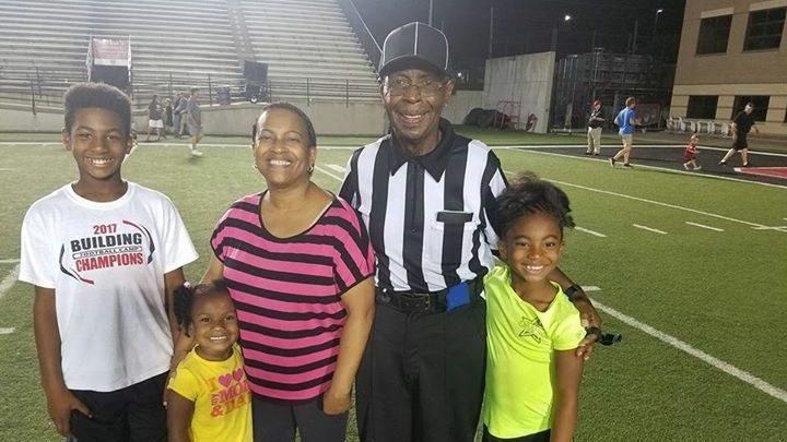 肾癌幸存者Primus Moore身着裁判制服在足球场上与家人合影