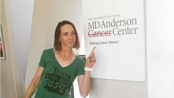 白血病幸存者艾米·马什与MD安德森癌症中心的标志合影
