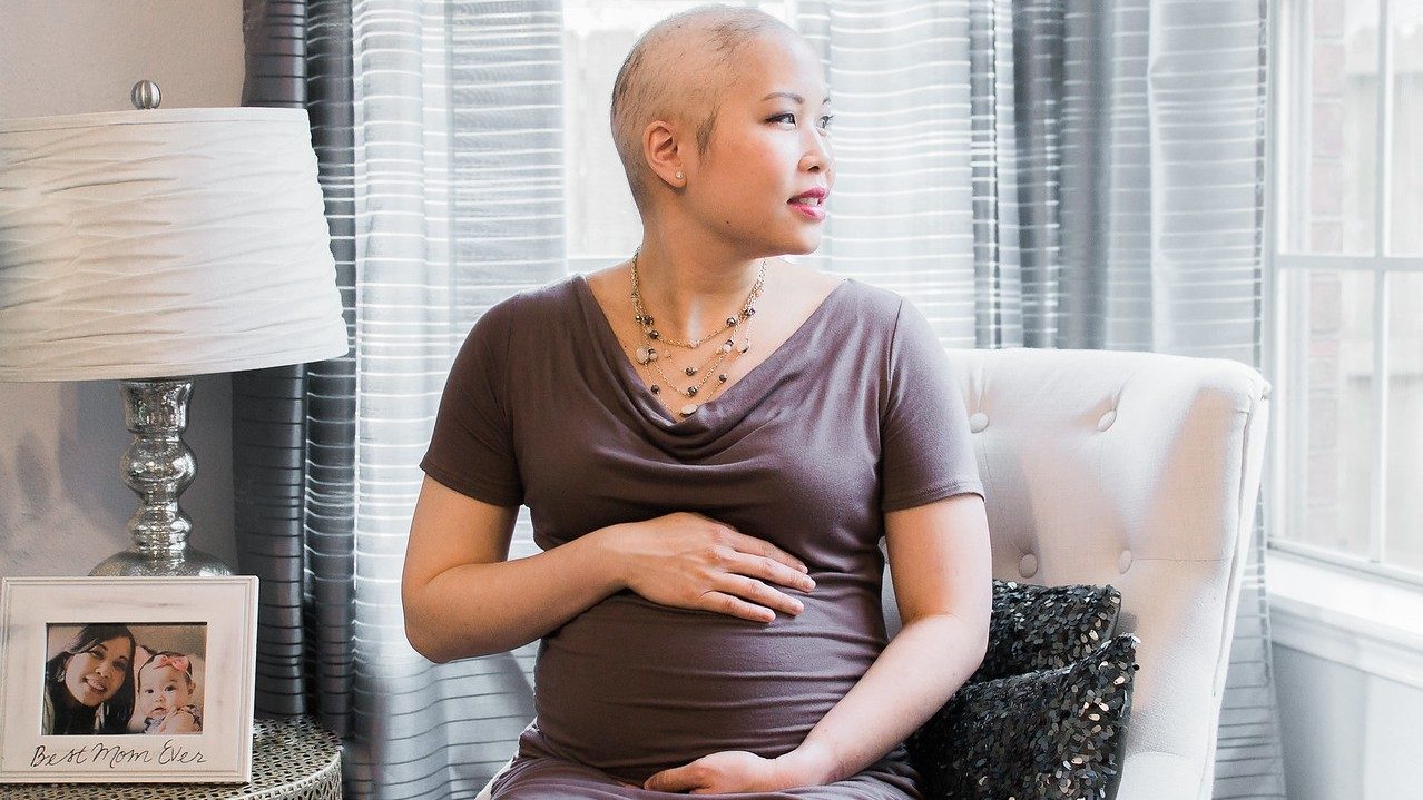 B细胞淋巴瘤幸存者艾莉莫雷诺与她怀孕的肚子姿势。