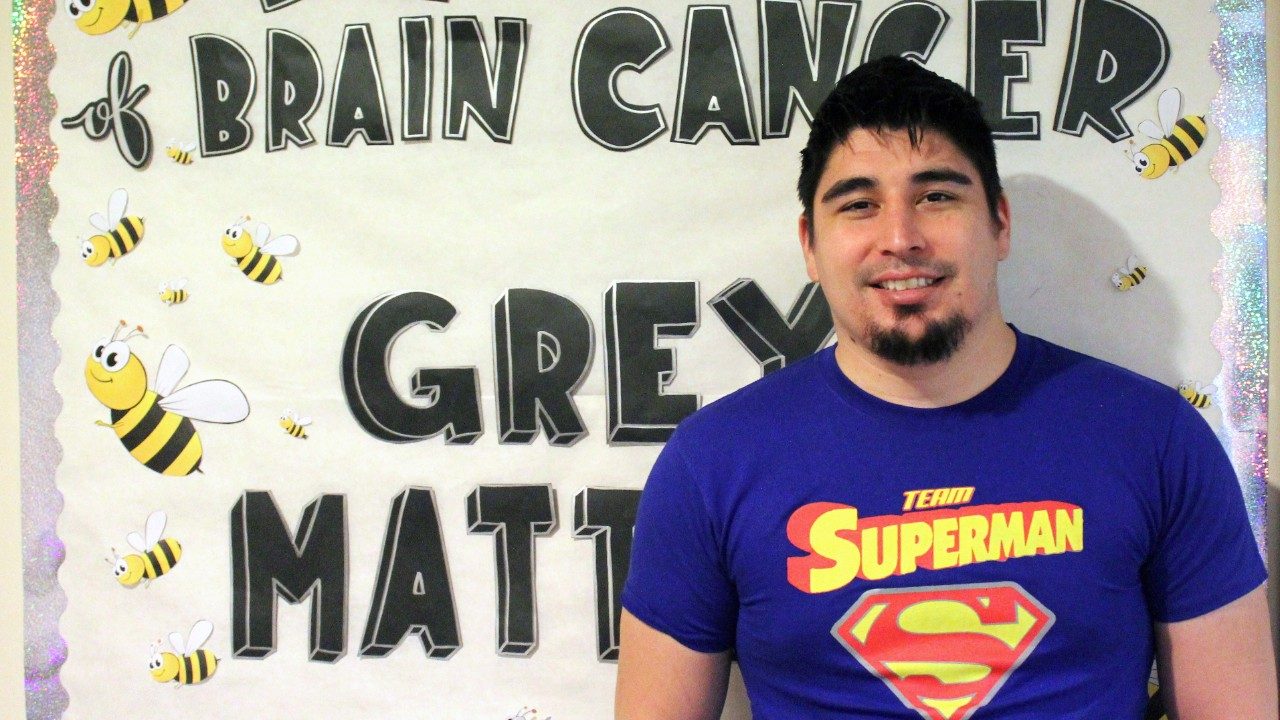 患有多形性黄色星形细胞瘤的脑瘤幸存者罗伯托·萨恩兹穿着一件“超人之队”的衬衫。