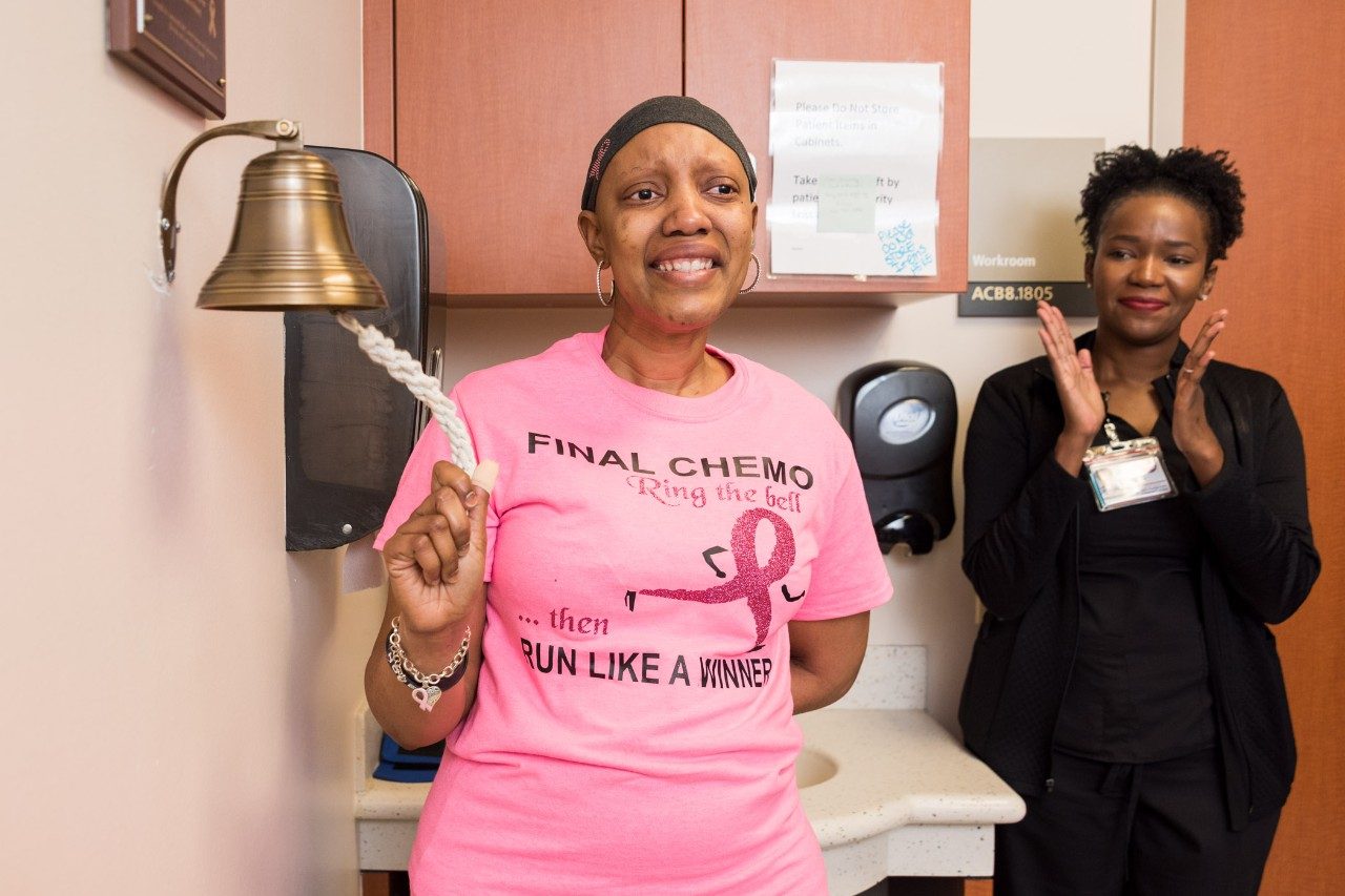 Triple-negative breast cancer survivor and MD Anderson employee Uniqua Smith, Ph.D., rings the bell to mark the end of her chemotherapy treatment