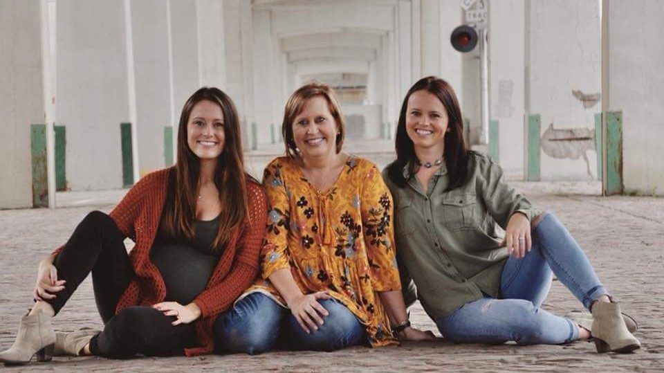 炎症乳腺癌幸存者Tiffany Honken与她的两个女儿姿势