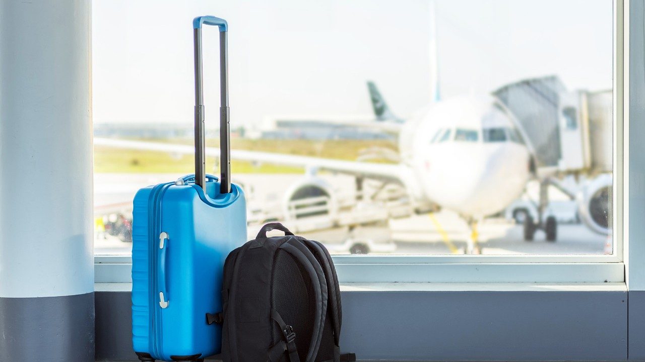 行李放在一扇可以俯瞰机场停机坪的窗户旁