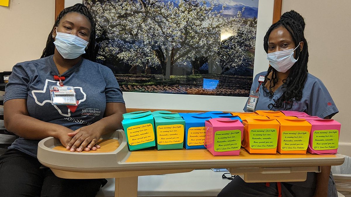 病人护理技术员Tequicha Price(右)和病人服务协调员Ashley Stacey站在他们为病人制作的灵感盒旁边。