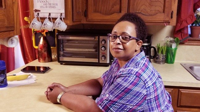 Trena罗伯逊坐在她的厨房柜台