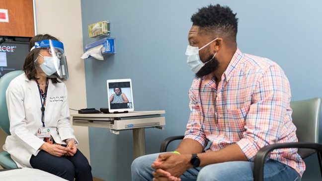 医生与年轻，非洲裔美国直肠癌患者讲话。