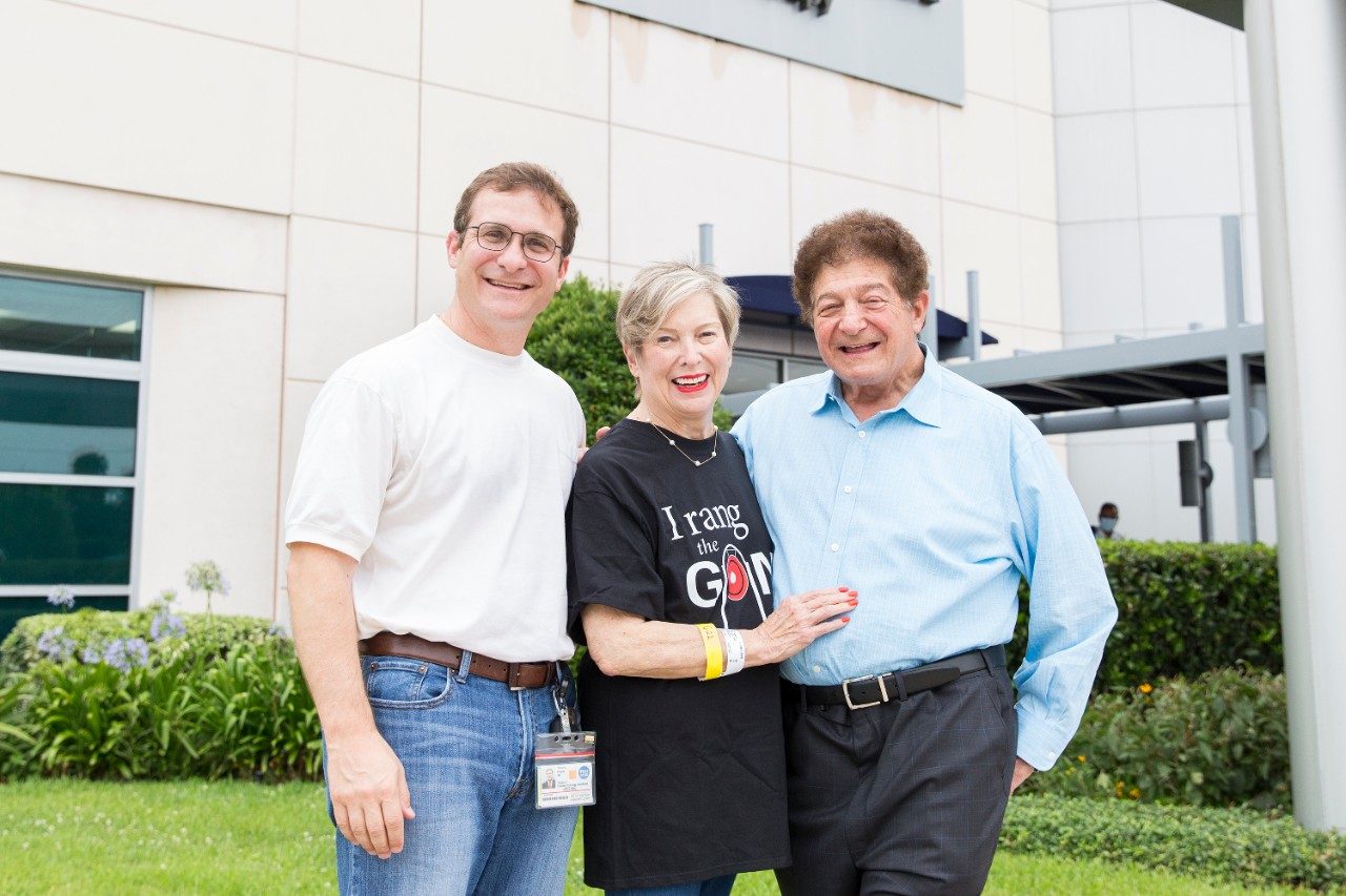 Cookie Frank站在MD Anderson质子治疗中心外，她的儿子Steven Frank，医学博士，她的丈夫Milton Frank III，医学博士
