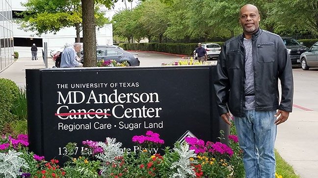 胰腺癌幸存者德鲁·哈金斯站在MD安德森旁边的糖地标志