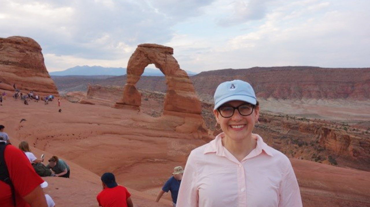 乳腺癌和白血病幸存者Julie Hildebrand，M.D.，在拱门国家公园戴着帽子和微笑