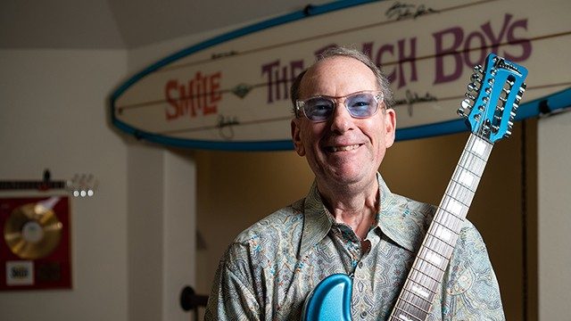 模拟甲状腺癌幸存者Jeffrey Fosket手持吉他时对相机笑