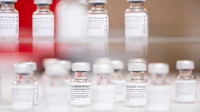 关闭-up of vials of COVID-19 vaccine on glass shelves