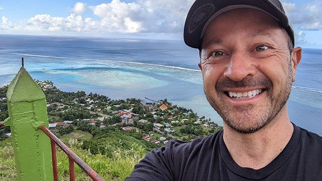 四期结直肠癌幸存者克里斯Sokolowski在博拉博拉岛的一个小山丘上,海洋的背景