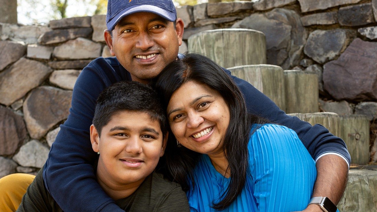 白血病的幸存者Arav帕蒂尔和他的父母,Komal(右)和拉胡尔,双臂Arav和Komal周围