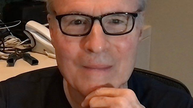 六次癌症幸存者亚瑟Hamberger,医学博士提出了一个黑色的t恤和黑框眼镜