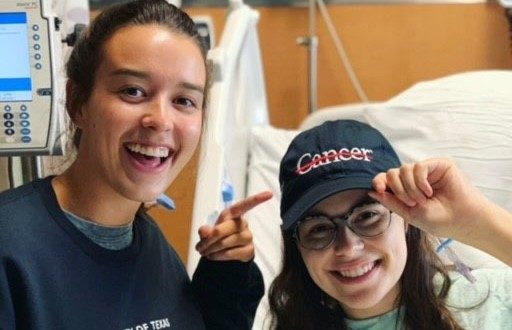 泰勒Fradella-Doucet(右)与她的妹妹见她手术后在2019年7月