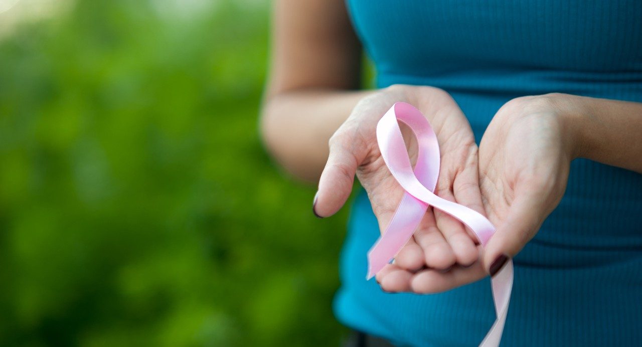 女人的手拿着粉红色的丝带用于乳腺癌意识