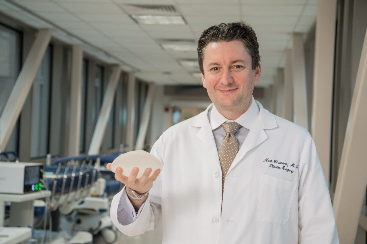 乳房植入相关间变性大细胞淋巴瘤专家Mark Clemens医学博士拿着一个有纹理的乳房植入物。