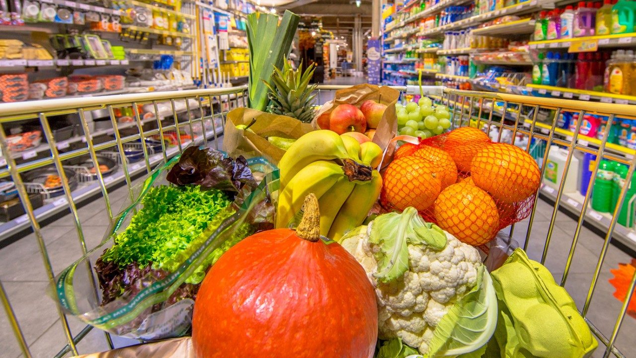 杂货店里有新鲜水果和蔬菜的购物车