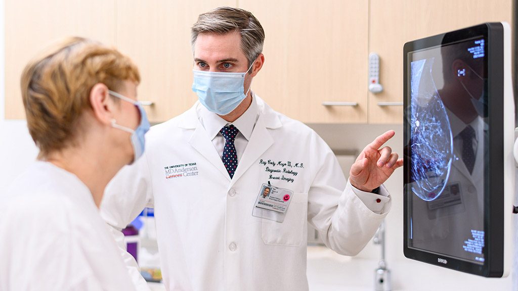 雷·梅奥三世，医学博士，为MD安德森联盟城的一位病人解释乳房x光检查